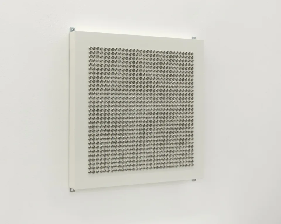 An angled view of a panel covered with metallic domes