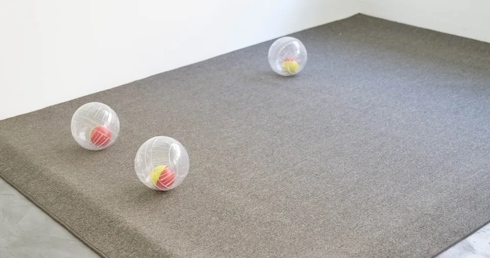 Three nested rolling balls arranged on a carpeted platform