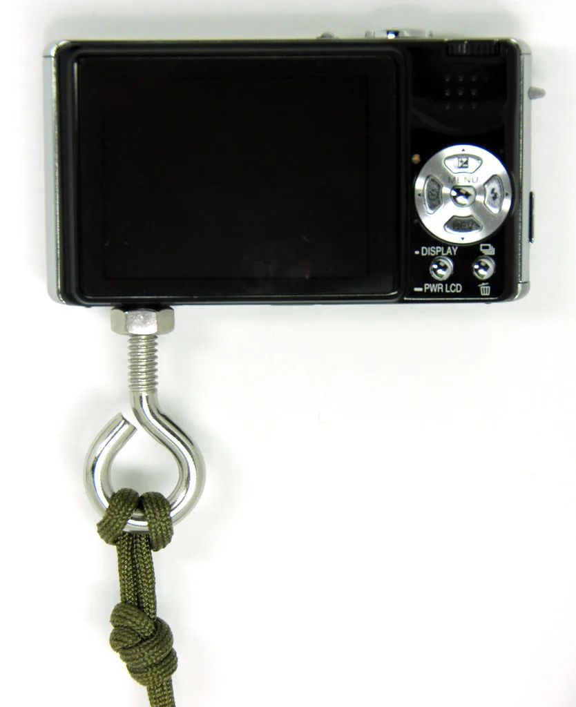 A cord attached by an eye bolt to a compact digital camera
