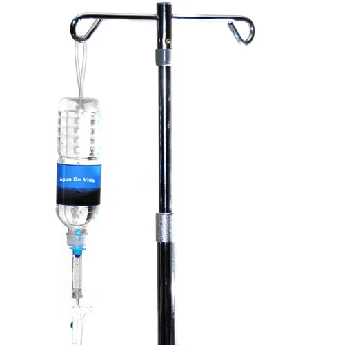 A clear IV bottle labeled Agua de Vida hanging from a metal stand