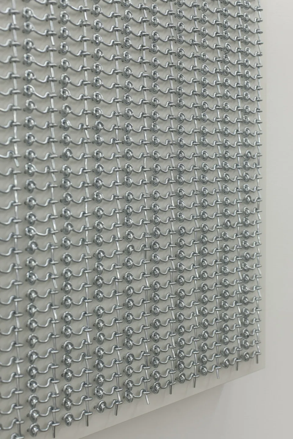 Oblique detail of rows of small metal hooks