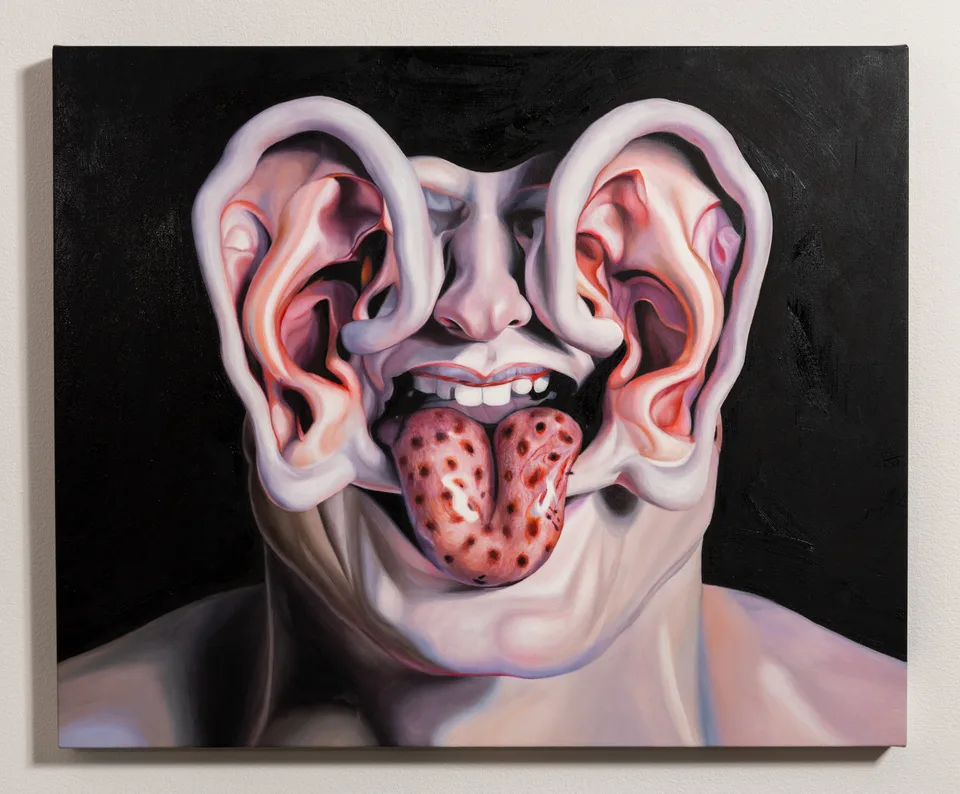 A painting of a face with two large ears, a nose, teeth and a spotted tongue, photographed straight on.