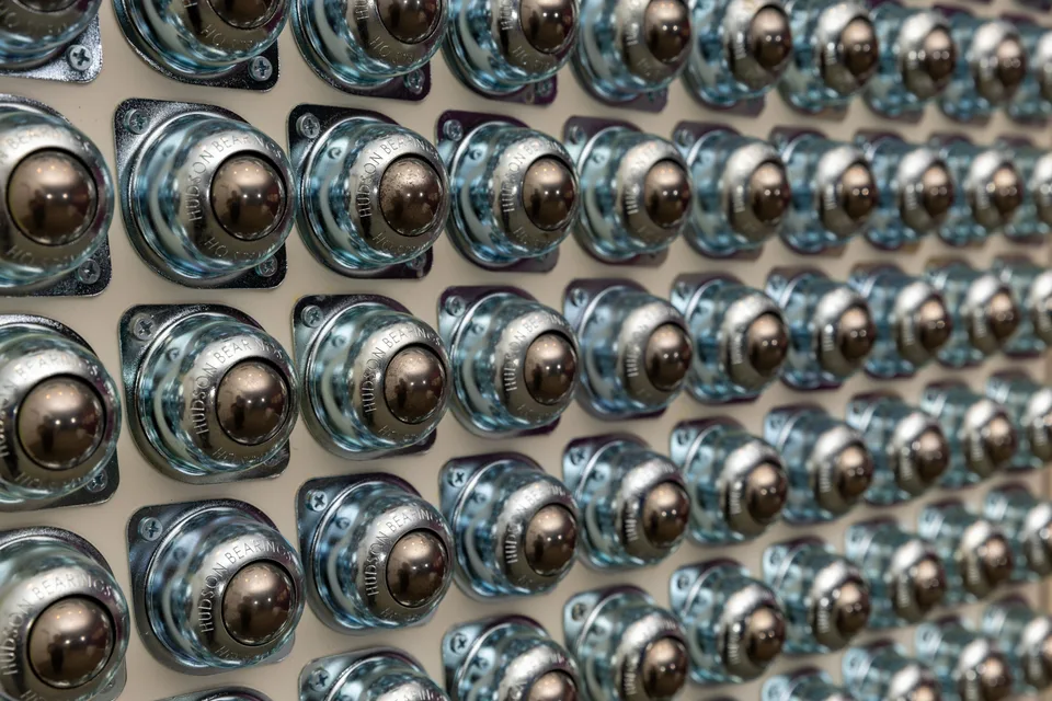 Rows of reflective steel ball-transfer bearings protrude from one square panel.