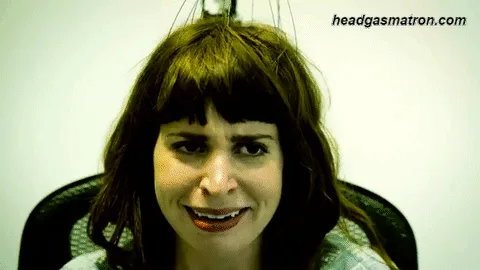A smiling participant receiving a mechanical head scratch