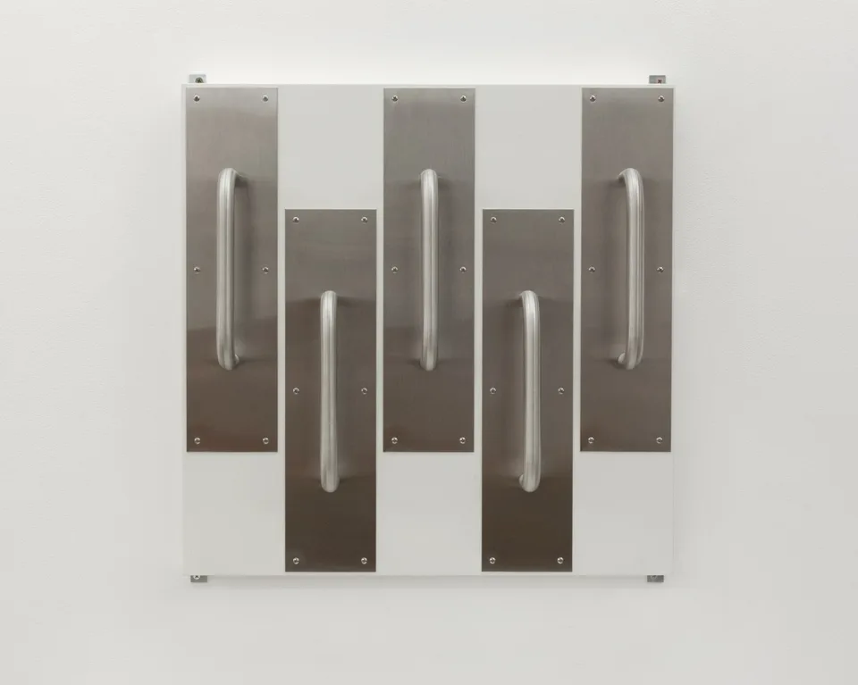 Five metal door handles mounted in an alternating arrangement