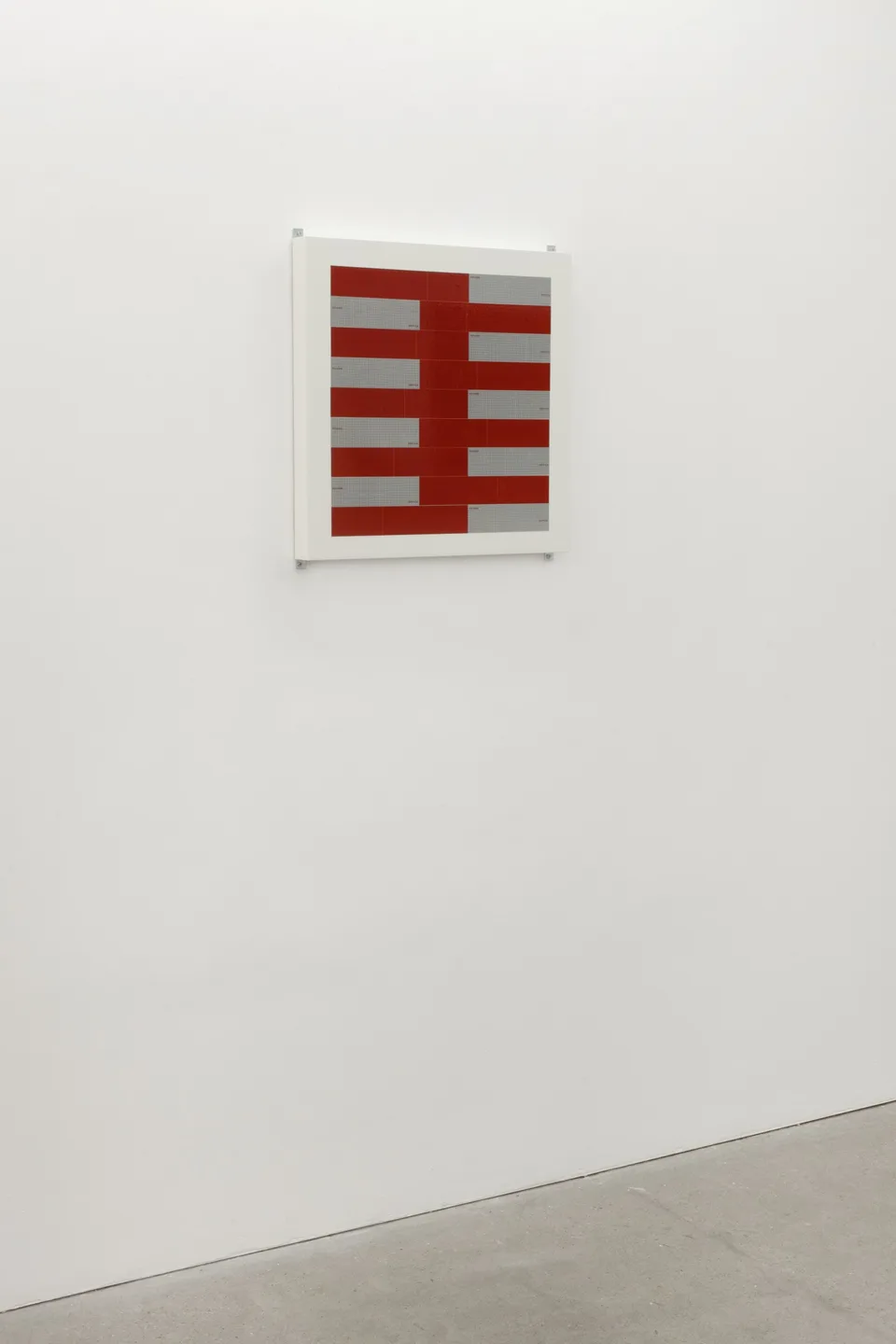 Red and silver strips arranged on a panel in the gallery