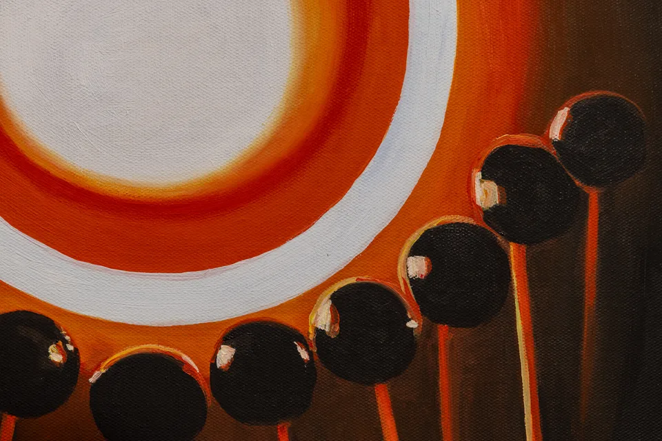 A close detail of orange rings and round dark forms in The Solar Dance.