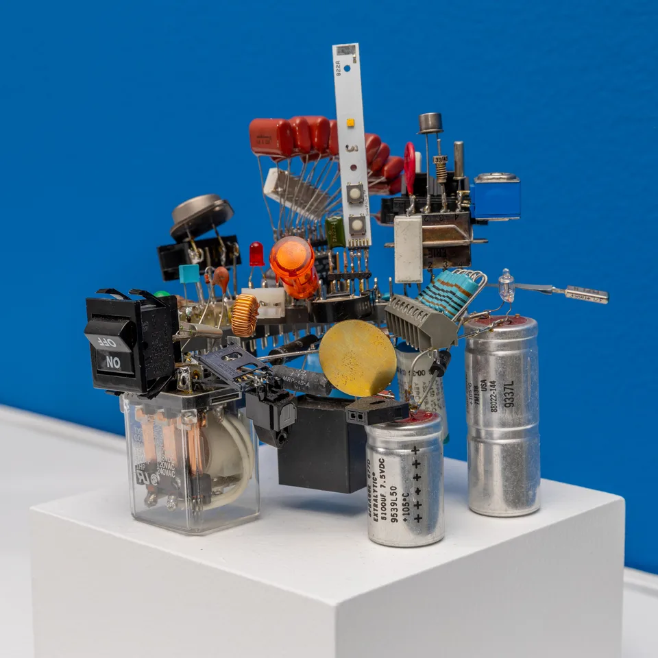 Three-quarter view of the electronic-component assemblage on a white plinth.