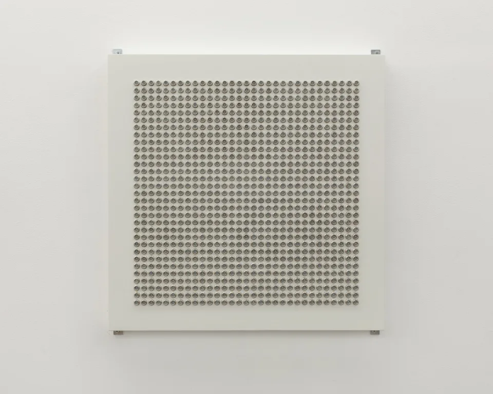 Front view of a square grid of small metallic domes