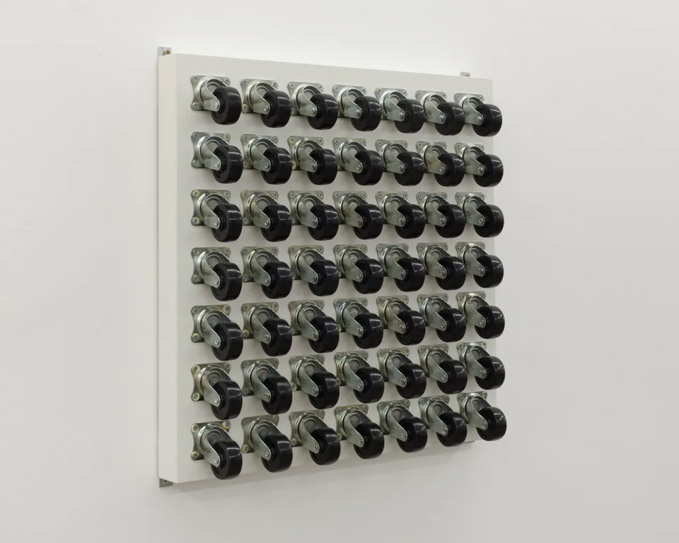 Angled view of a square panel of caster wheels