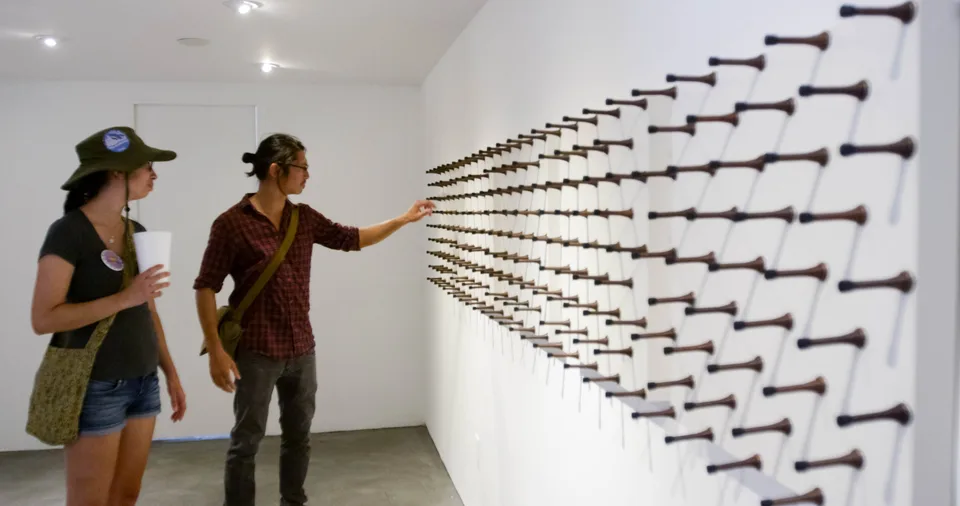Visitors touching spring door stops at Charlie James Gallery